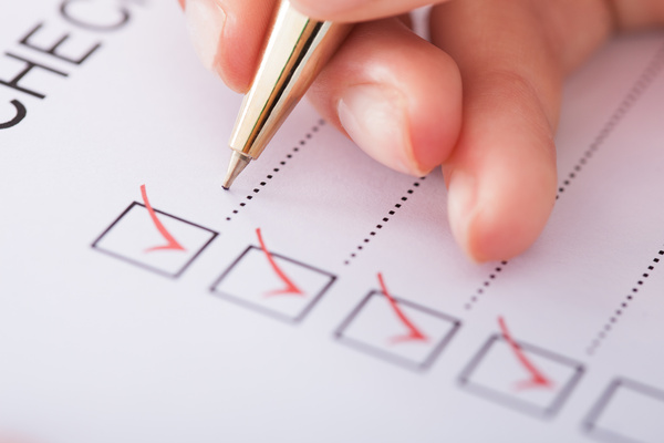 Cropped image of businesswoman writing on checklist