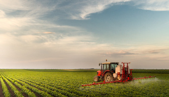 Tractor spraying pesticides at  soy bean fields